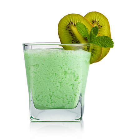 Glass of kiwi smoothie with fruits and fresh green mint leaves isolatedの写真素材