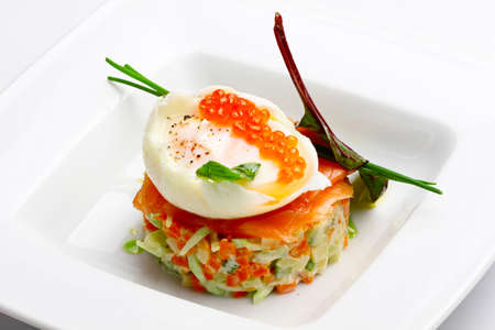 Russian salad with salmon and red caviar on wight backgroundの写真素材