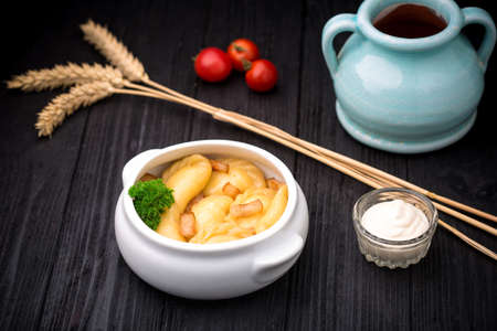 Dumplings with potatoes and cracknel on black rustic wooden backgroundの写真素材