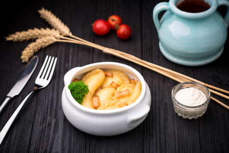Dumplings with potatoes and cracknel on black rustic wooden backgroundの写真素材