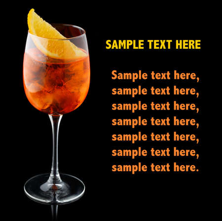 Orange alcohol cocktail with orange slice isolated on black. Place for text.の写真素材