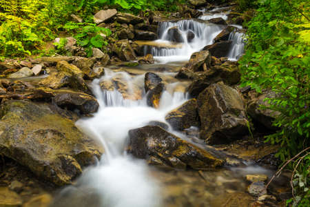 Forest creek with waterfalls. Water cascades over rocks in Ukrainian Carpathians.の写真素材