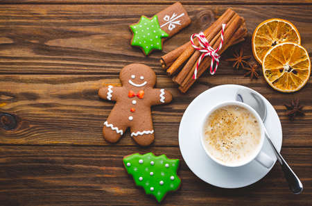 Christmas homemade gingerbread cookies with spices and cup of cacao on the wooden backgroundの写真素材