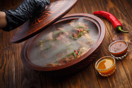 Delicious barbecued ribs seasoned with a spicy basting sauce  on old rustic wooden boardの写真素材