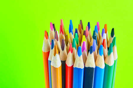 A set of colored pencils for drawing on bright green background macro photographyの写真素材