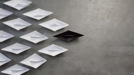 Business Concept, Paper Boat, the key opinion Leader, the concept of influence. One black paper boat as the Leader, leading in the direction of the white ships on a gray concrete background,flat layの写真素材