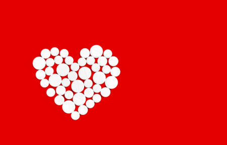 White medicine pills in the shape of a heart on a red background top view with copy space.