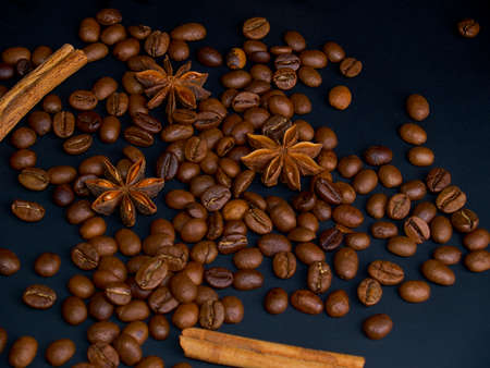 Roasted arabica coffee beans, cinnamon sticks and anise stars on a dark wooden background,close-upの写真素材