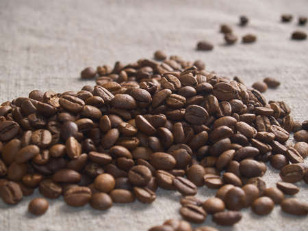 Roasted coffee beans scattered on a burlap napkin.の写真素材