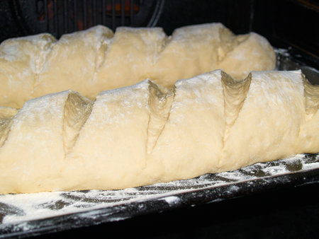 Before baking, the dough lies on a baking sheet sprinkled with flour in the ovenの写真素材