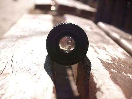 close up photo of old camera lens over wooden table. image is retro filtered. selective focusの写真素材