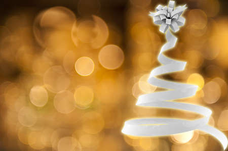 Christmas tree made of ribbon against gold lightの写真素材