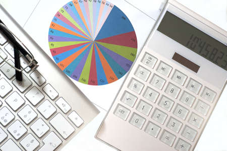 Statistics elements in a desk with calculator and keyboardの写真素材