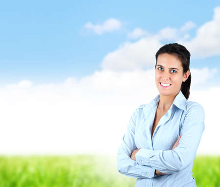 Business woman smiling in front of a green lawnの写真素材