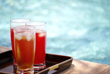 cocktails on tray on a swimming pool background