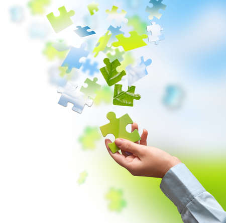 Green piece of a puzzle in handの写真素材