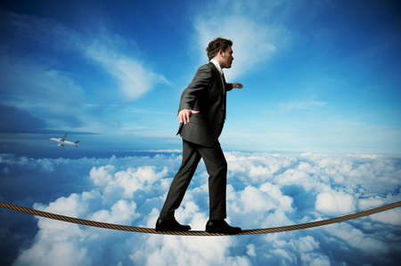 Businessman is balancing on a ropeの写真素材