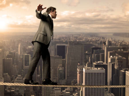 Businessman is balancing on a ropeの写真素材