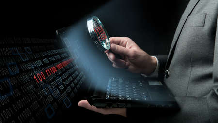 Businessman searching virus in a laptopの写真素材