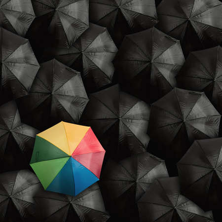 Concept of leader with with many blacks and a colorful umbrellaの写真素材