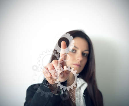 Businesswoman works with gear on virtual systemの写真素材