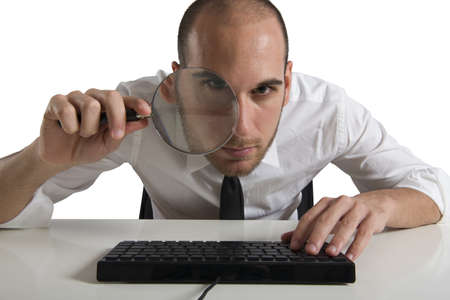 Businessman  looks on the computer with a magnifying glassの写真素材