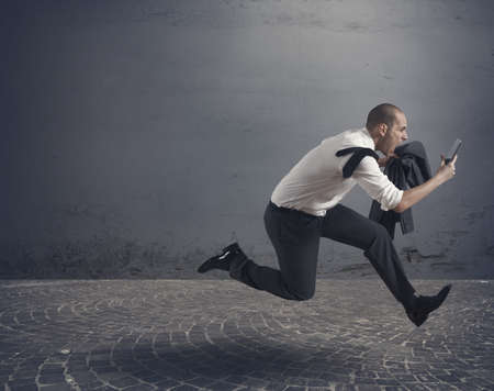Stressed business running with tabletの写真素材