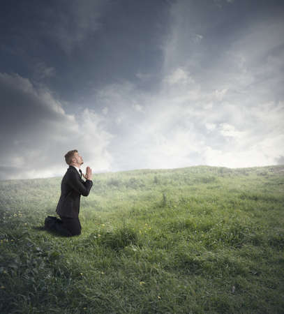 Businessman is praying to solve the financial crisisの写真素材