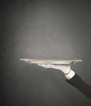 First-class service with waiter holding the trayの写真素材