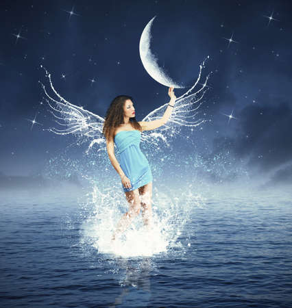 Creative fashion with fairy touching the moonの写真素材