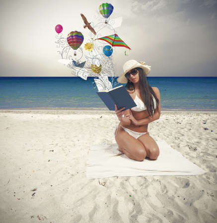 Girl relaxing in a beach with bookの写真素材
