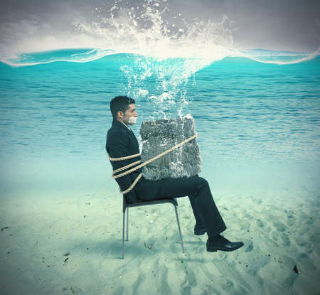 Businessman trapped in a chair with ropeの写真素材