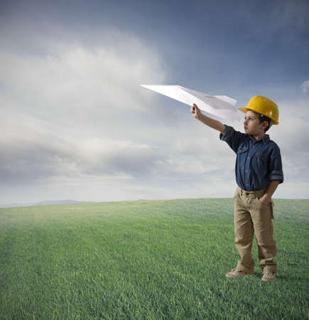 Young boy tries to fly a paper planeの写真素材