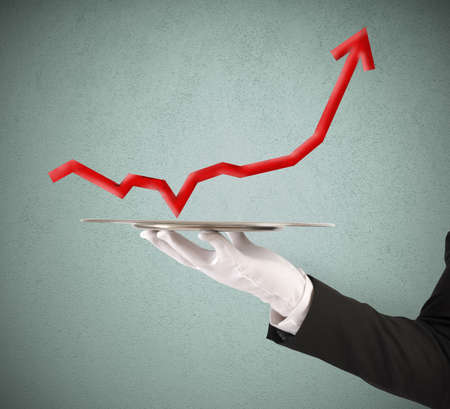 Businessman holds a tray with red statisticsの写真素材