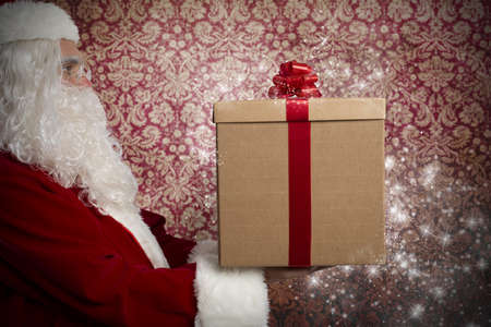 Santa Claus with present in a homeの写真素材