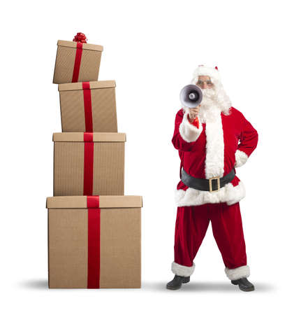 Santa Claus with megaphone with stack giftsの写真素材