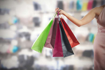 A woman holding several colorful shopping bagsの写真素材