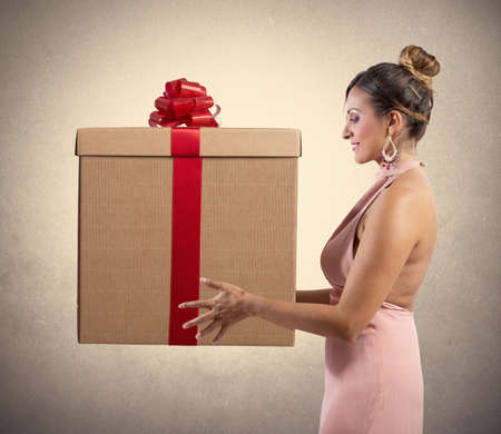 Fashion girl holds a big Christmas presentの写真素材