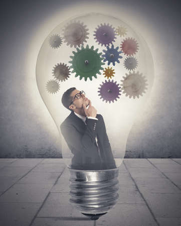 Businessman thinking about new idea inside a lampの写真素材