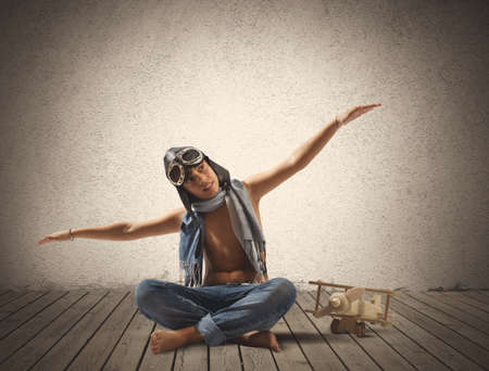Young boy playing with toy airplane in a roomの写真素材