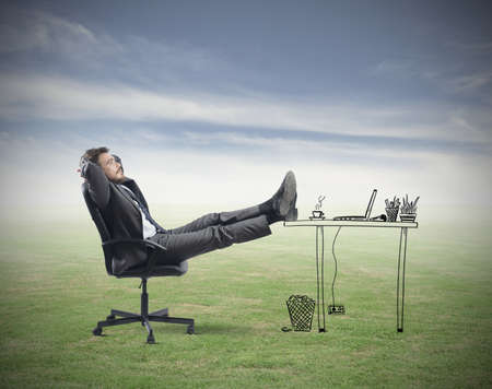 Successful businessman relaxing in an imaginary officeの写真素材