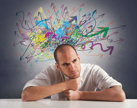 Confusion of a businessman with colorful arrowの写真素材