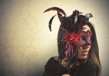 Beautiful woman with red and black carnival maskの写真素材