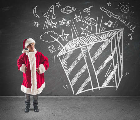 Child dressed as Santa Claus dreams of Christmas giftsの写真素材