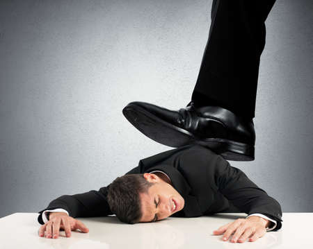 Concept of oppressed by the boss with businessman under a big shoe