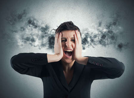 Stressed businesswoman with smoke coming out of his earsの写真素材