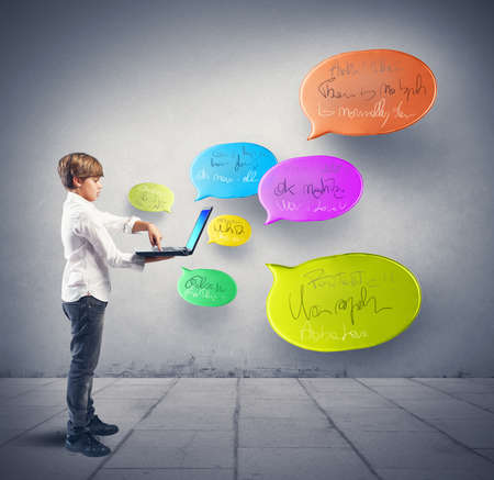 Boy writes messages to social networks with computerの写真素材