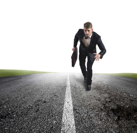 Business in action with running businessman in a roadの写真素材