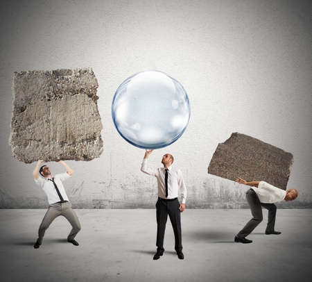 Concept of easy business with businessman holding a soap ball instead of the rockの写真素材