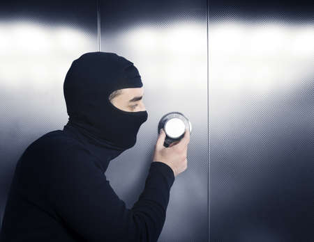 A thief tries to open a safe in a bankの写真素材